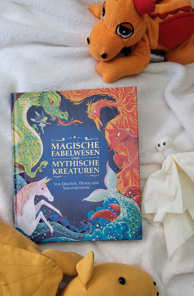 Das fabelhafte Lexikon „Magische Fabelwesen und mythische Kreaturen“ umgeben von Drachen und Geist