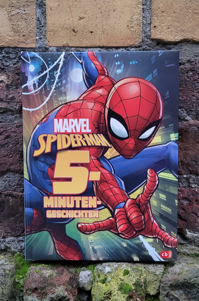 Das Vorlesebuch „Spider-Man 5-Minuten-Geschichten“ vor einer alten Backsteinmauer