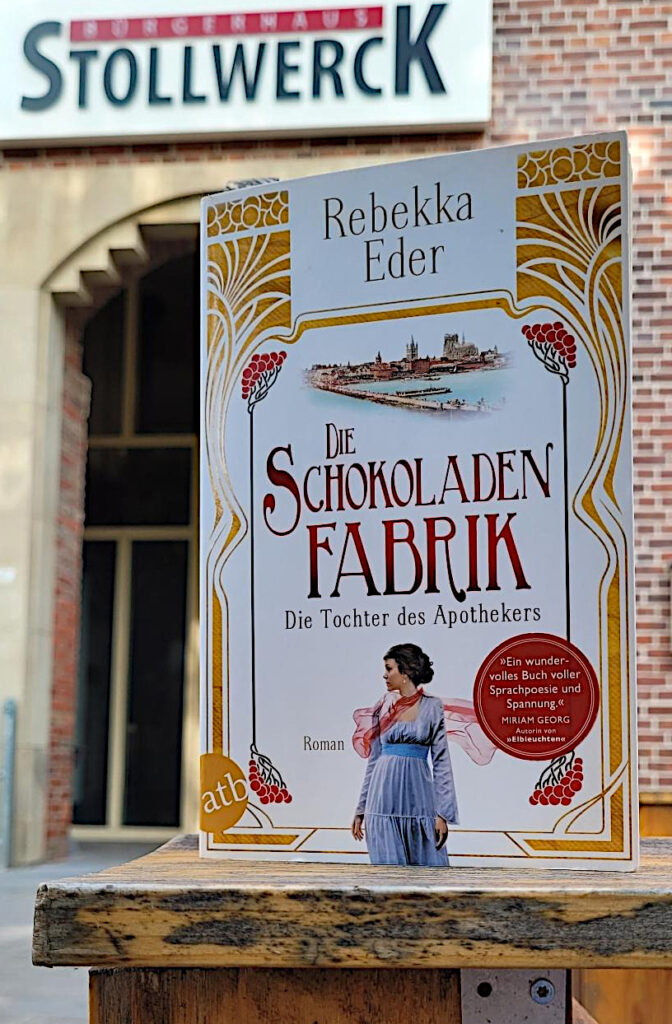Der historische Roman „Die Schokoladenfabrik - Die Tochter des Apothekers“ von Rebekka Eder vor dem Bürgerhaus Stollwerck in Köln