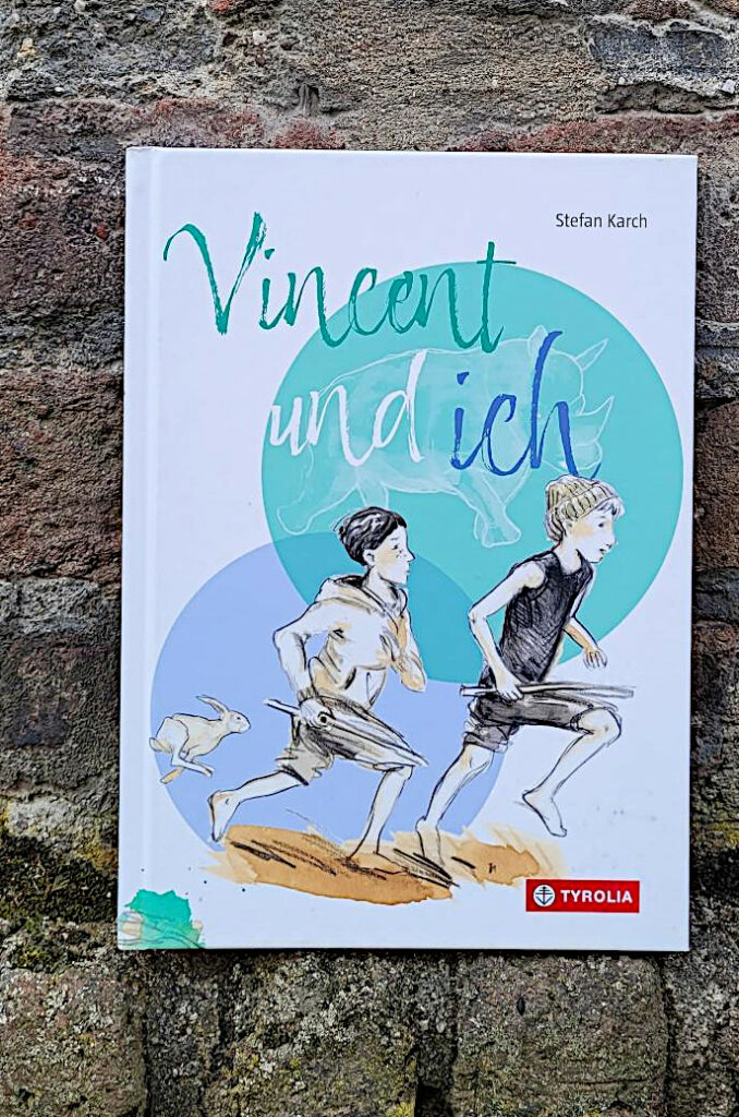 Das Bilderbuch „Vincent und ich“ von Stefan Karch vor einer alten Backsteinmauer
