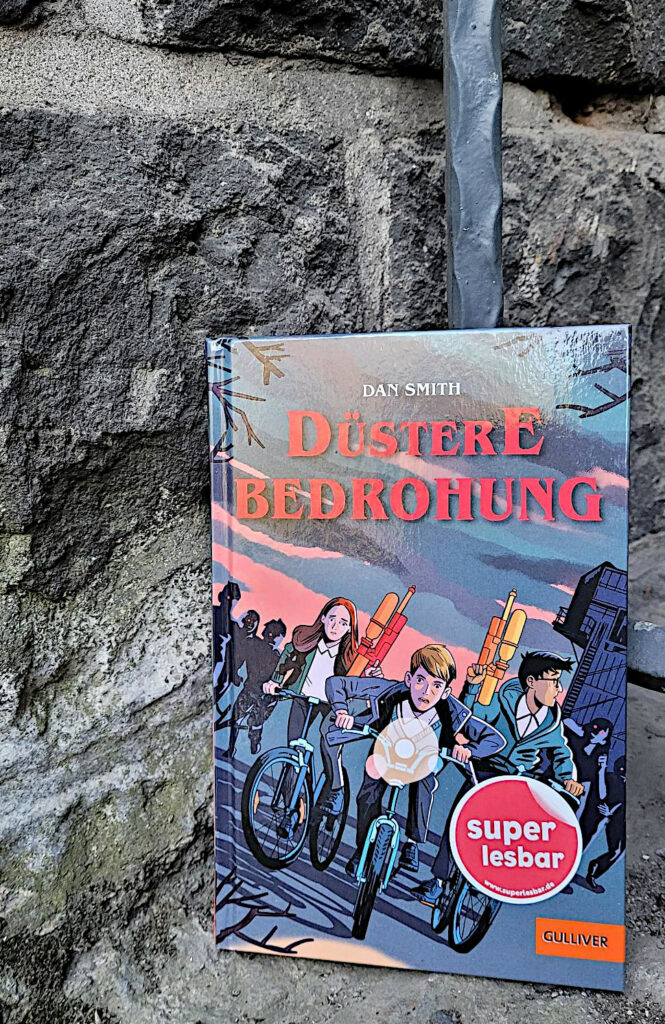 Das Super Lesbar-Buch: „Düstere Bedrohung“ von Chris Priestley vor einer alten Steinmauer
