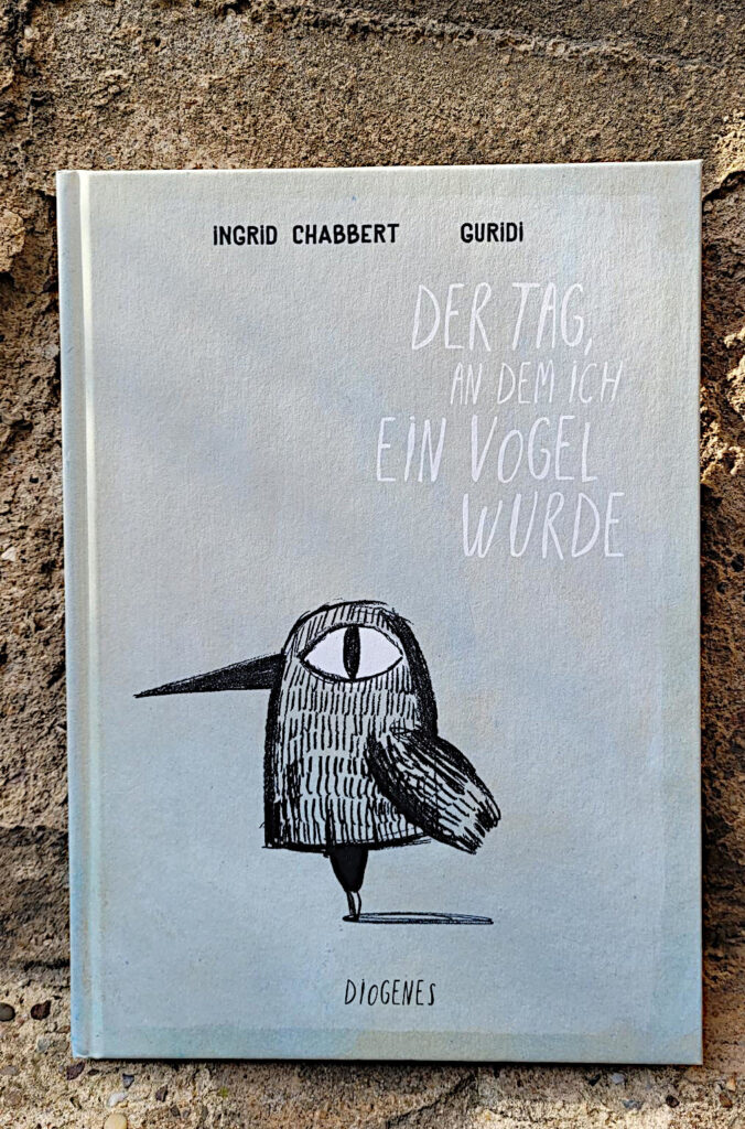 Das Buch „Der Tag, an dem ich ein Vogel wurde“ von Ingrid Chabbert und Raúl Nieto Guridi vor einer alten Wand mit bröckeligem Putz