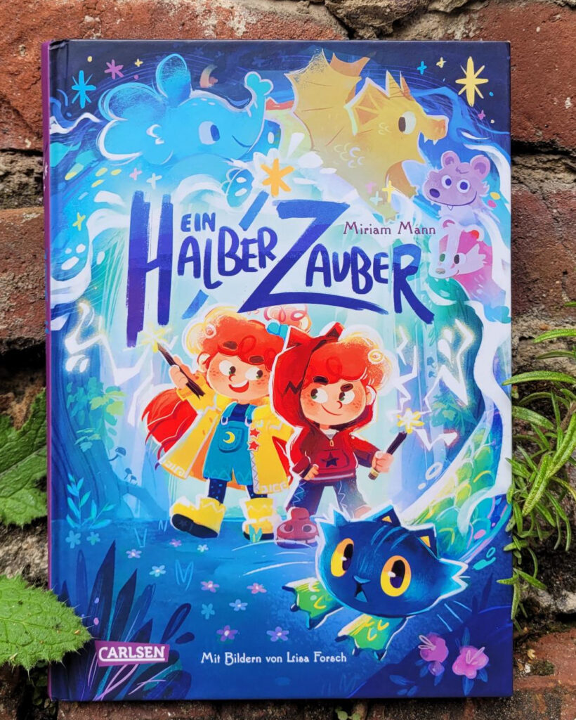 Das Kinderbuch „Ein halber Zauber“ von Miriam Mann und Lisa Forsch vor einer alten Backsteinmauer